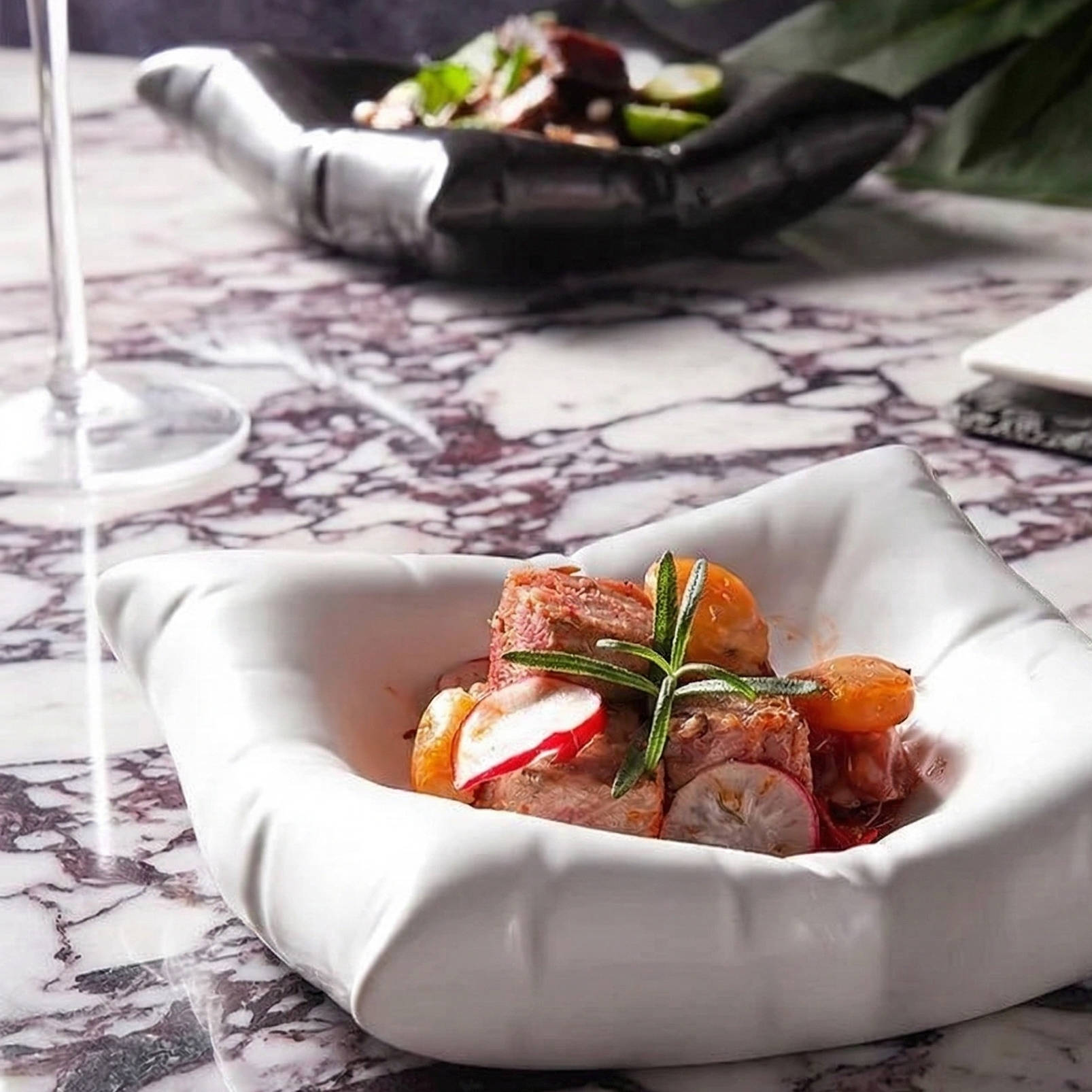 white pasta dish on a marble counter with a glass of white wine.