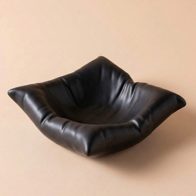Black porcelain bowl on a beige background